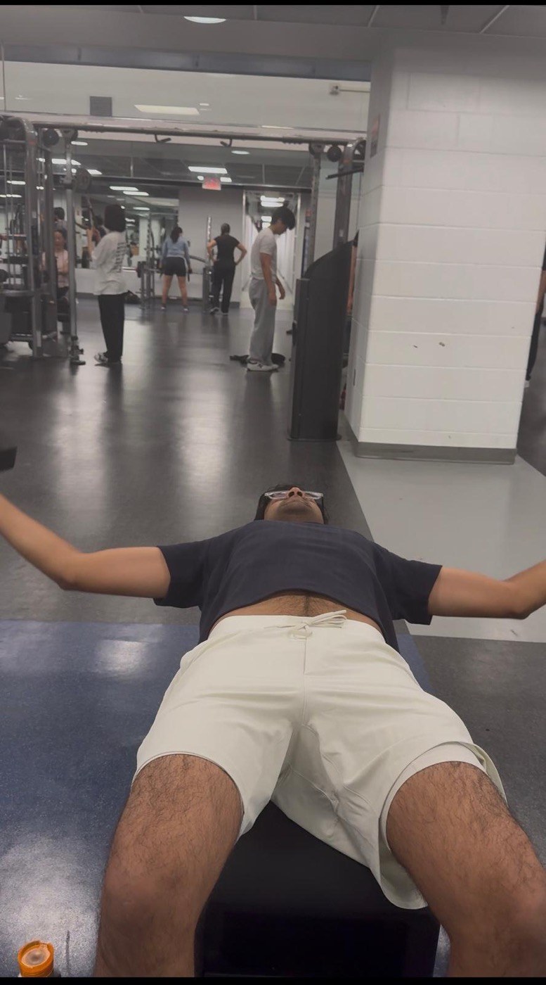 Pranav lying completely flat on a gym bench
